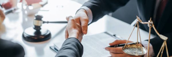 Lawyer who provides legal advice in the office. Businessman and lawyer shaking hands.